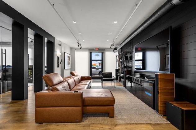 Eyehear Showroom living room with TV, speakers and suede furniture