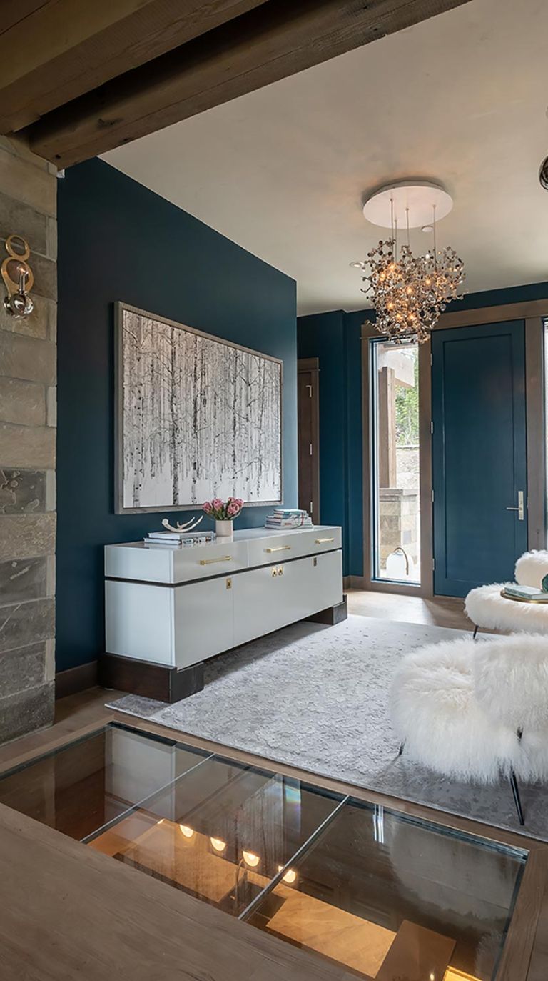 Modern entryway featuring a blue accent wall and unique crystal chandelier